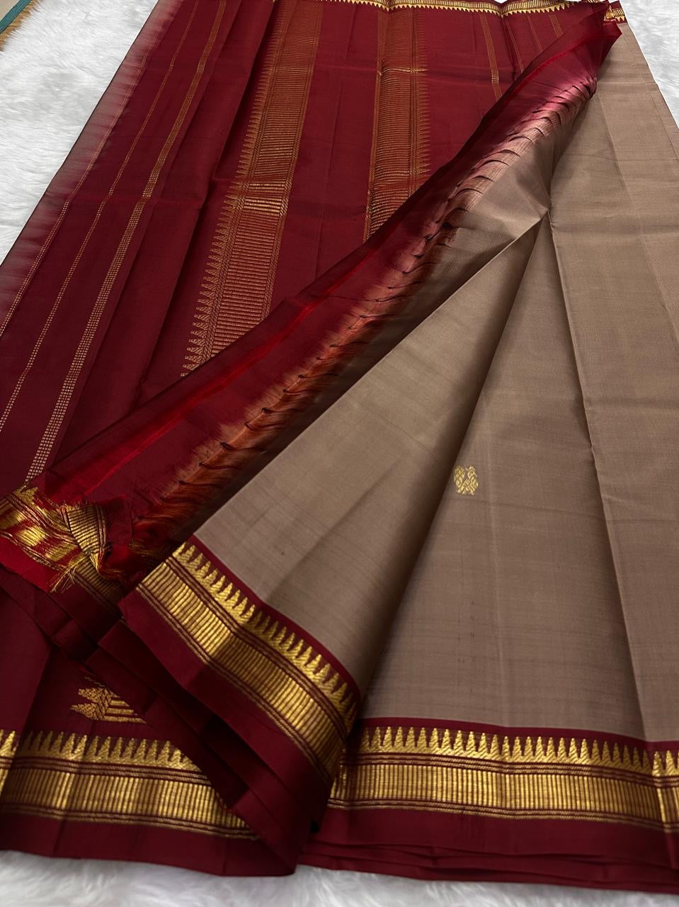 Stacked view of pure Kanchipuram silk saree highlighting beige silk body and maroon zari border