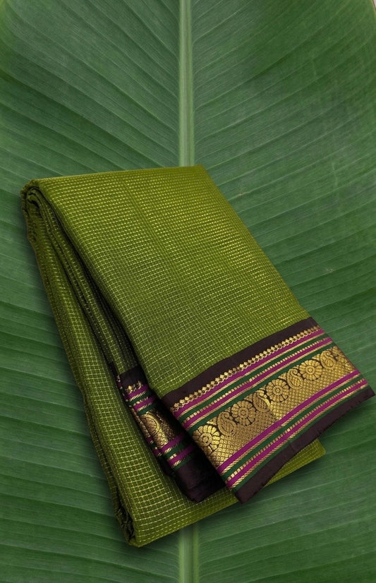 Betel leaf green Kanchipuram silk saree with dark purple brown korvai border and kumkum pink silk thread detailing folded view