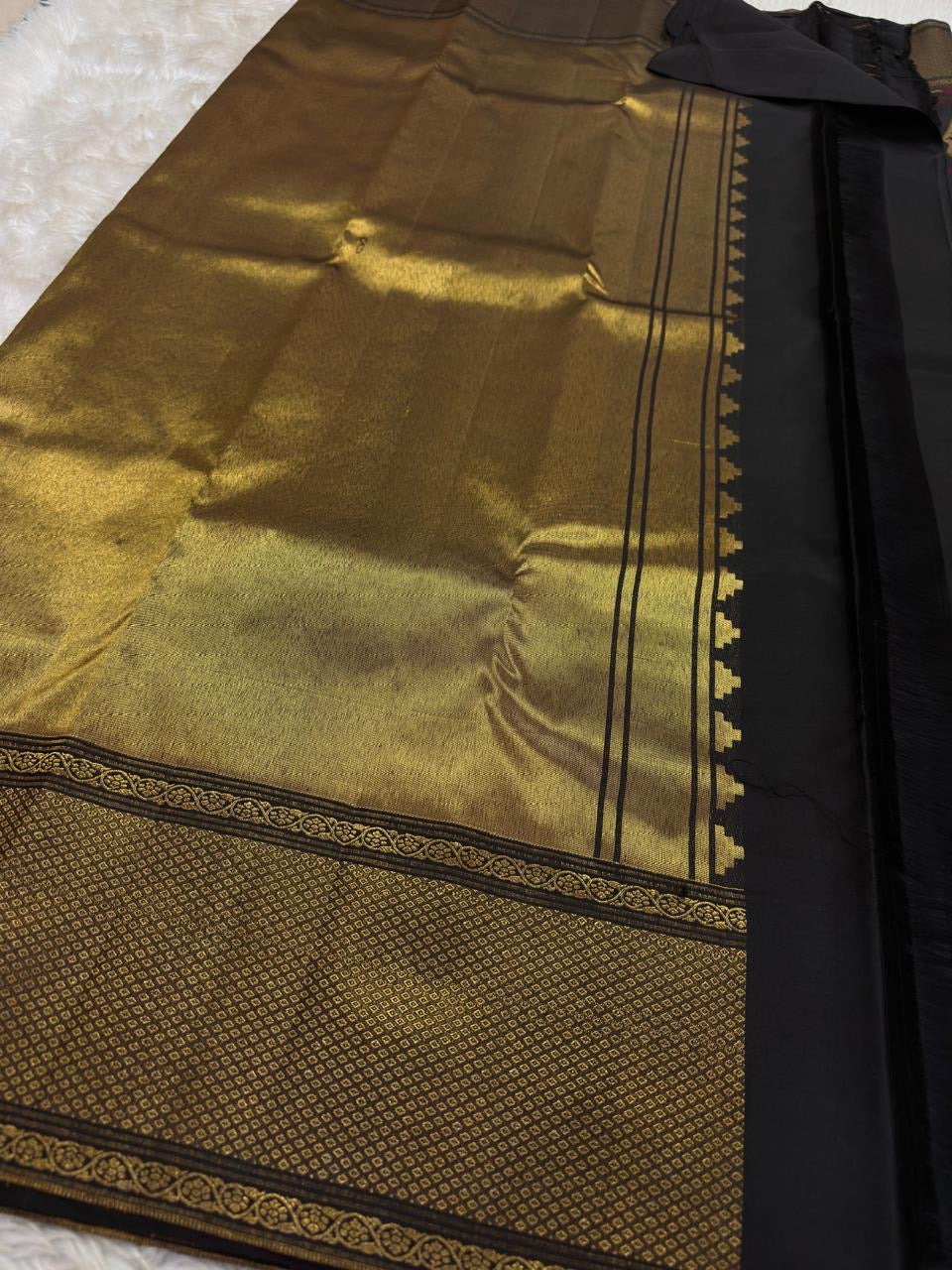 Close view of broad antique-gold geometric zari border on Midnight Black Kanjivaram silk.