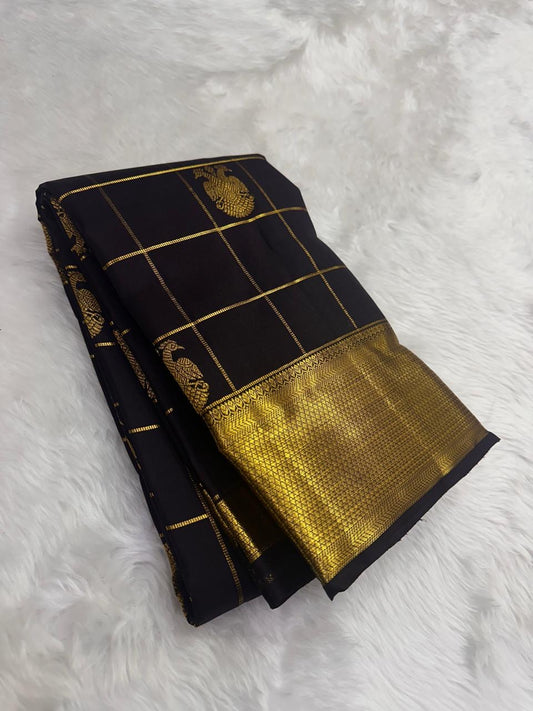 Folded black kanchipuram silk saree with gold zari checks and wide gold border