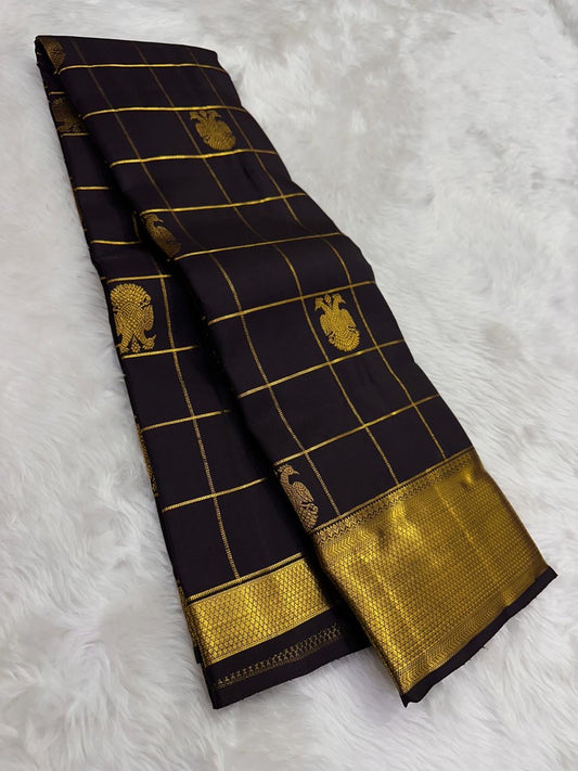 Black kanchipuram silk saree laid lengthwise with gold zari grid checks and gold border detail