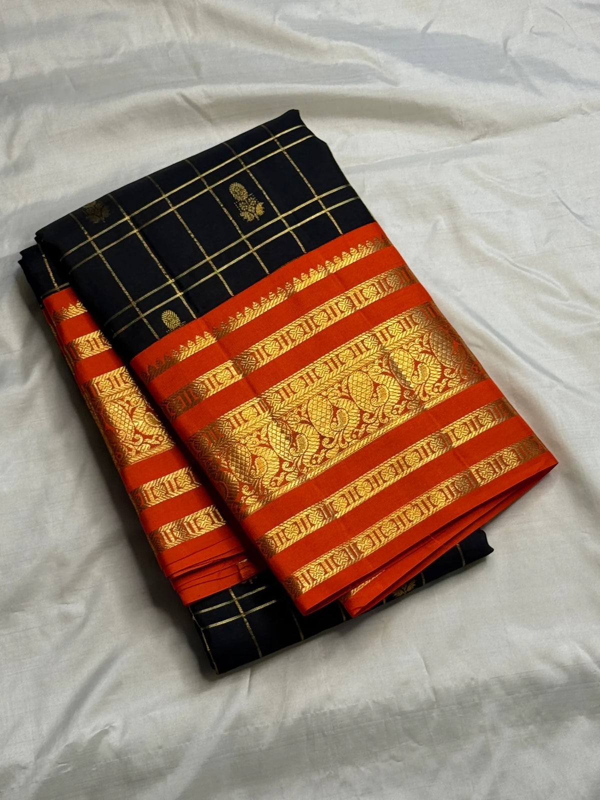 Handwoven black Pure Silk Kanchipuram Zari Kattam saree with burnt-orange and classic-gold contrast.
