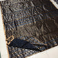 Black body close-up showing silver-gold pinstripe detail