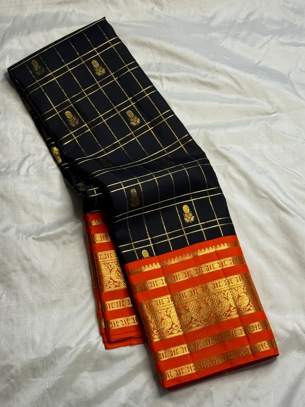 Deep black Kanchipuram silk body with fine classic-gold Zari Kattam grid lines and spaced gold zari buttas.