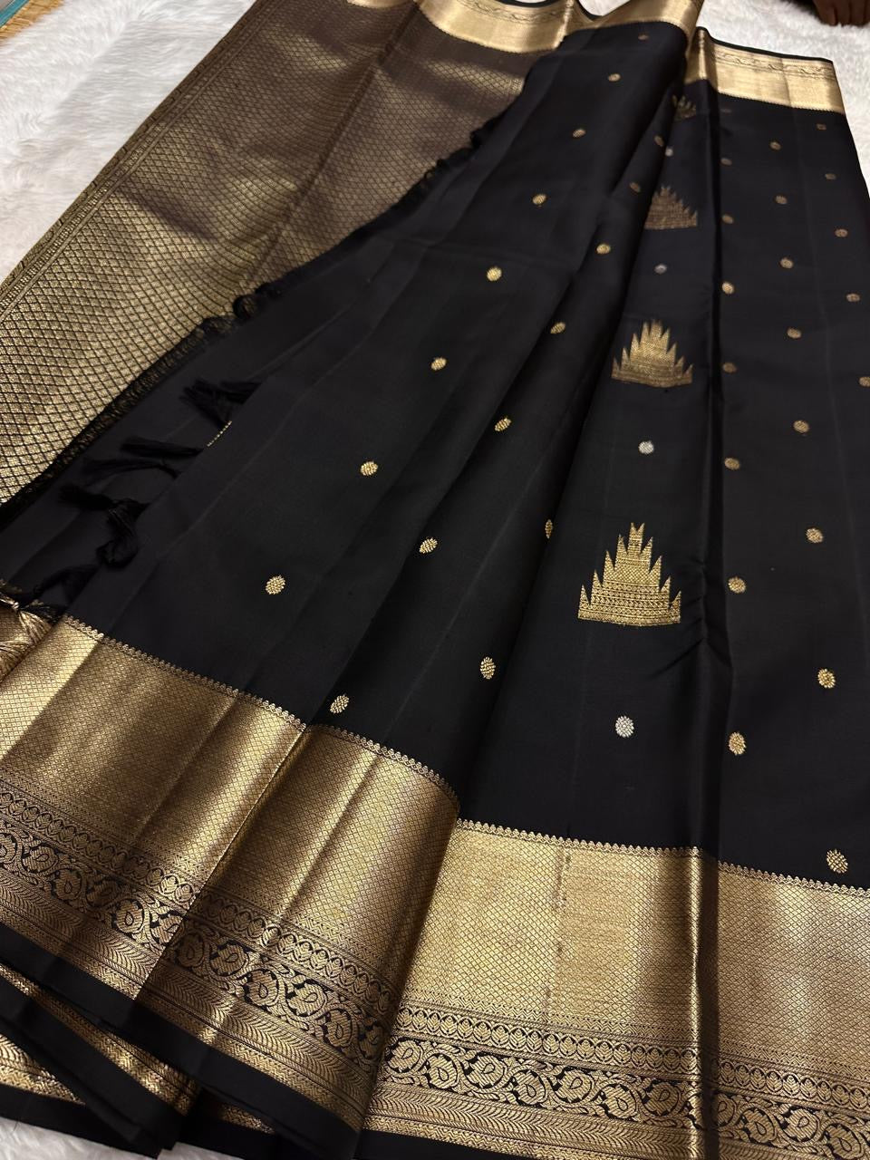 Black handwoven Kanchipuram silk saree with antique-gold zari and broad traditional border.
