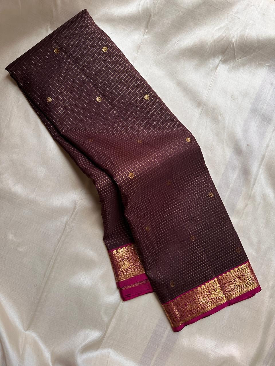 Draped deep brown checked pure Kanchipuram silk saree with small gold buttas and magenta zari border