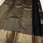 Close view of traditional Thazhampoo Reku zari butta on black Kanchipuram silk.