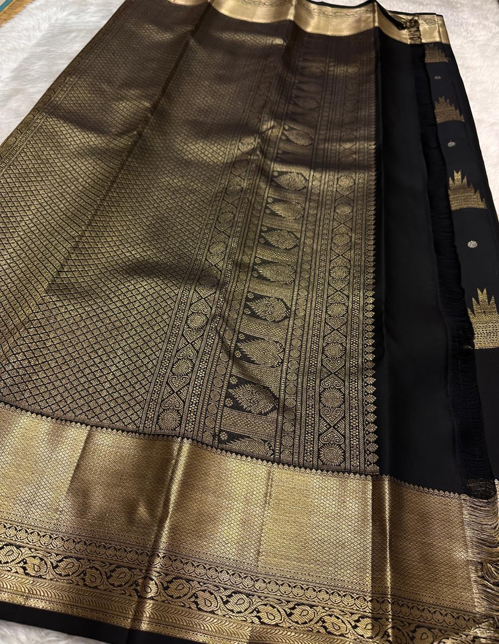 Close view of traditional Thazhampoo Reku zari butta on black Kanchipuram silk.