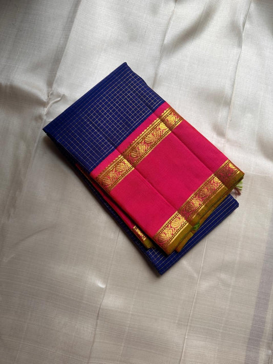 Pure Kanchipuram silk saree folded on ivory background with blue body woven in fine gold checks and bright pink zari border