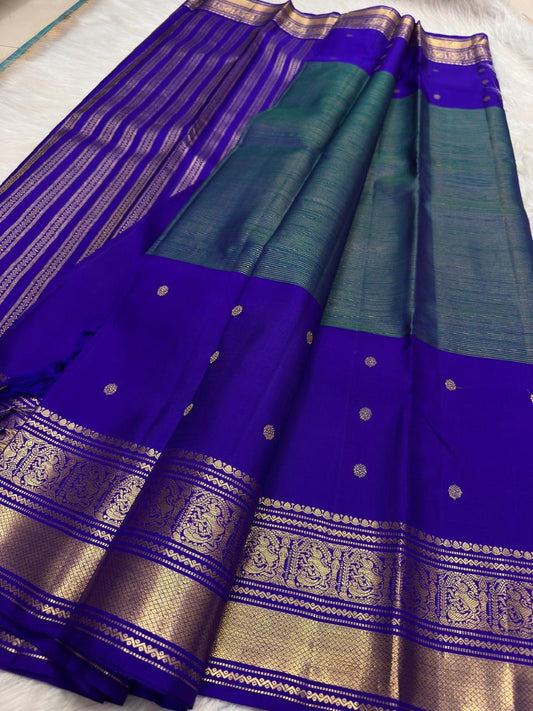 Close view of antique-gold zari butta on Mayil Kazhuthu blue-green Kanjivaram silk.