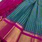 Close view of checked Kanchipuram silk saree with magenta border, gold zari panel, and tassels along the edge