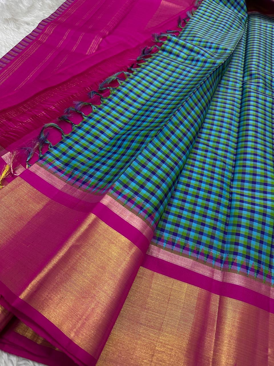 Close view of checked Kanchipuram silk saree with magenta border, gold zari panel, and tassels along the edge