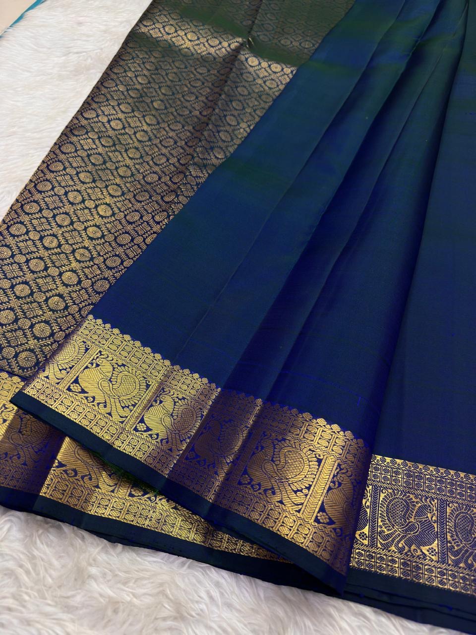Close view of handwoven warm-gold zari paisley buttas on Mayil Kazhuthu pure silk