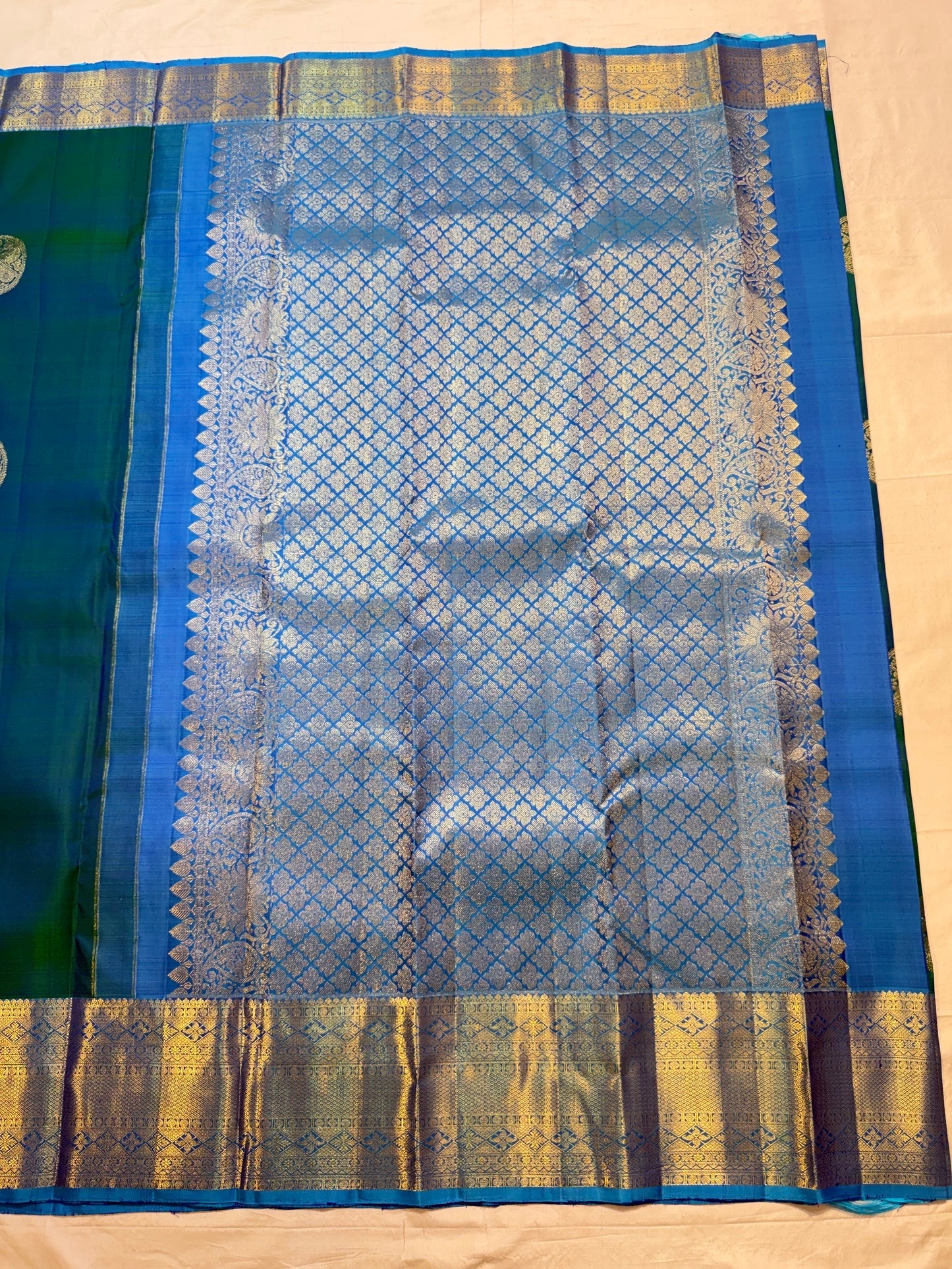 Sky Blue Kanchipuram pallu with dense gold zari lattice, floral ornamental registers and Peacock Blue-Green silk body.
