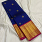 Blue Kanchipuram silk saree folded lengthwise with small gold zari buttas and a wide gold zari border with pink edge.