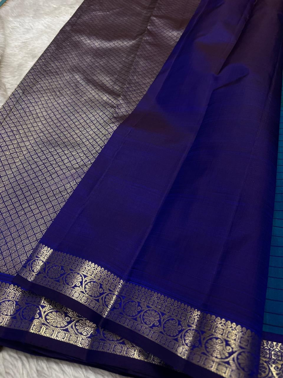 Indigo pallu section with silver zari woven border and smooth silk finish