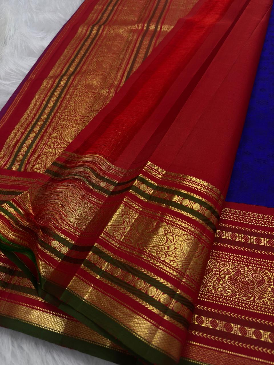 Pillar-box red and olive-green peacock border, royal-blue Kanchi Pattu saree