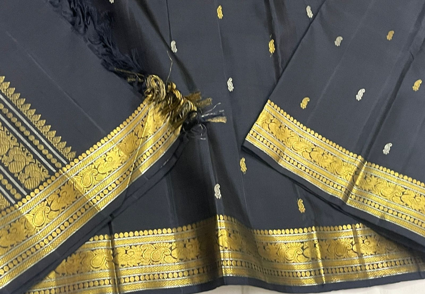 Pallu of midnight black Kanchipuram silk saree with dense geometric zari weave and coordinating antique gold border detailing.