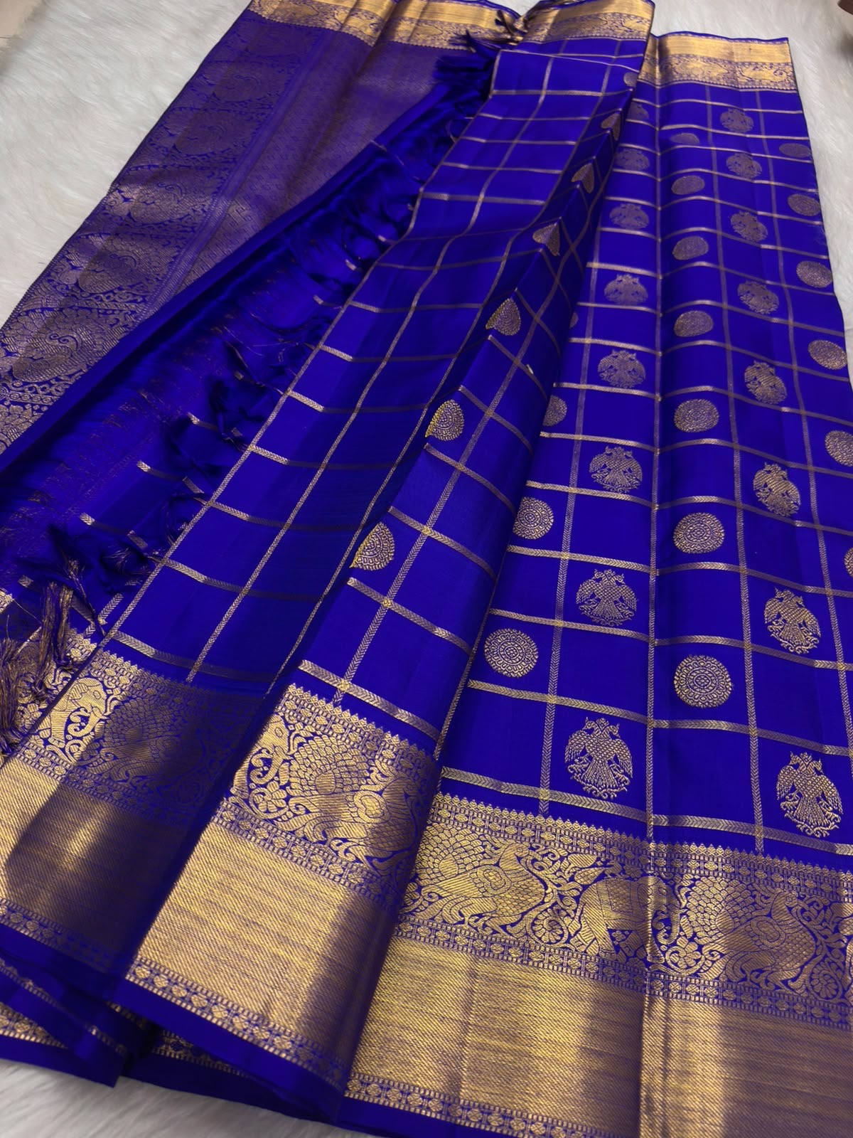 Deep Violet Pure Silk Kanchipuram saree with vivid blue undertone, antique gold Zari Kattam grid, Gandaberunda motifs and broad gold border.