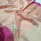 Blush Peach Pattu Silk Chanderi saree folded to show silver floral buttas with Rani Pink accents and contrast edge