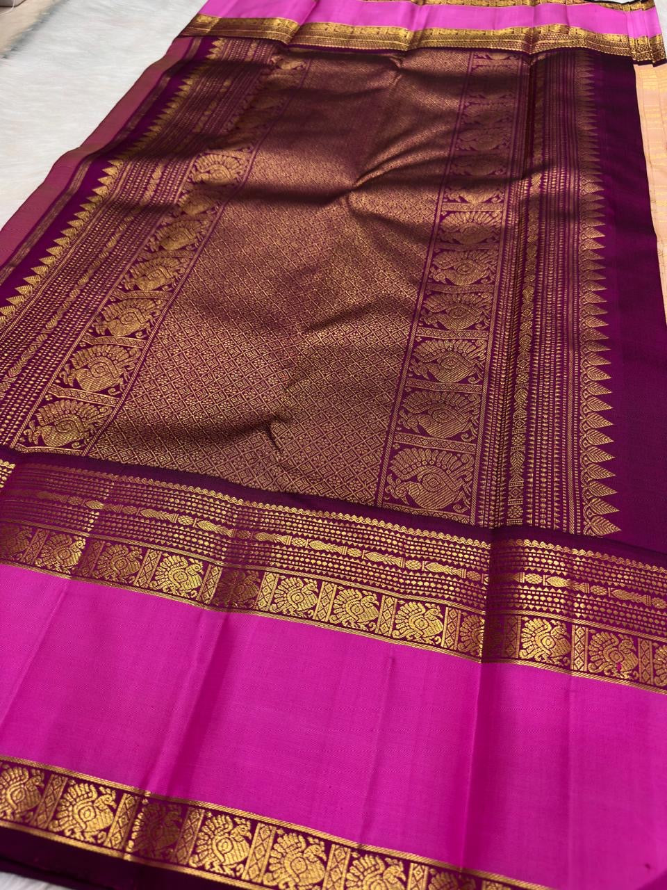 Vivid pink and deep aubergine Rettapet border detail on blush peach Kanjivaram saree