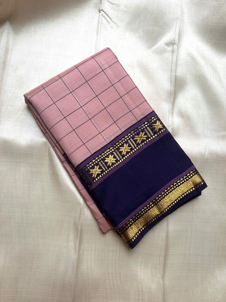 Folded blush pink checked pure Kanchipuram silk saree with deep navy zari woven border featuring star motifs, available in the USA