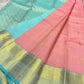 Draped blush pink pure Kanchipuram silk saree showing small gold buttas and wide zari woven border with sky blue edging