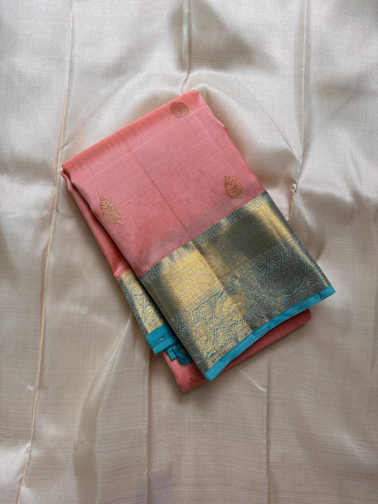 Folded blush pink pure Kanchipuram silk saree with sky blue border and gold zari woven pallu, flat lay, shipped from New Jersey USA