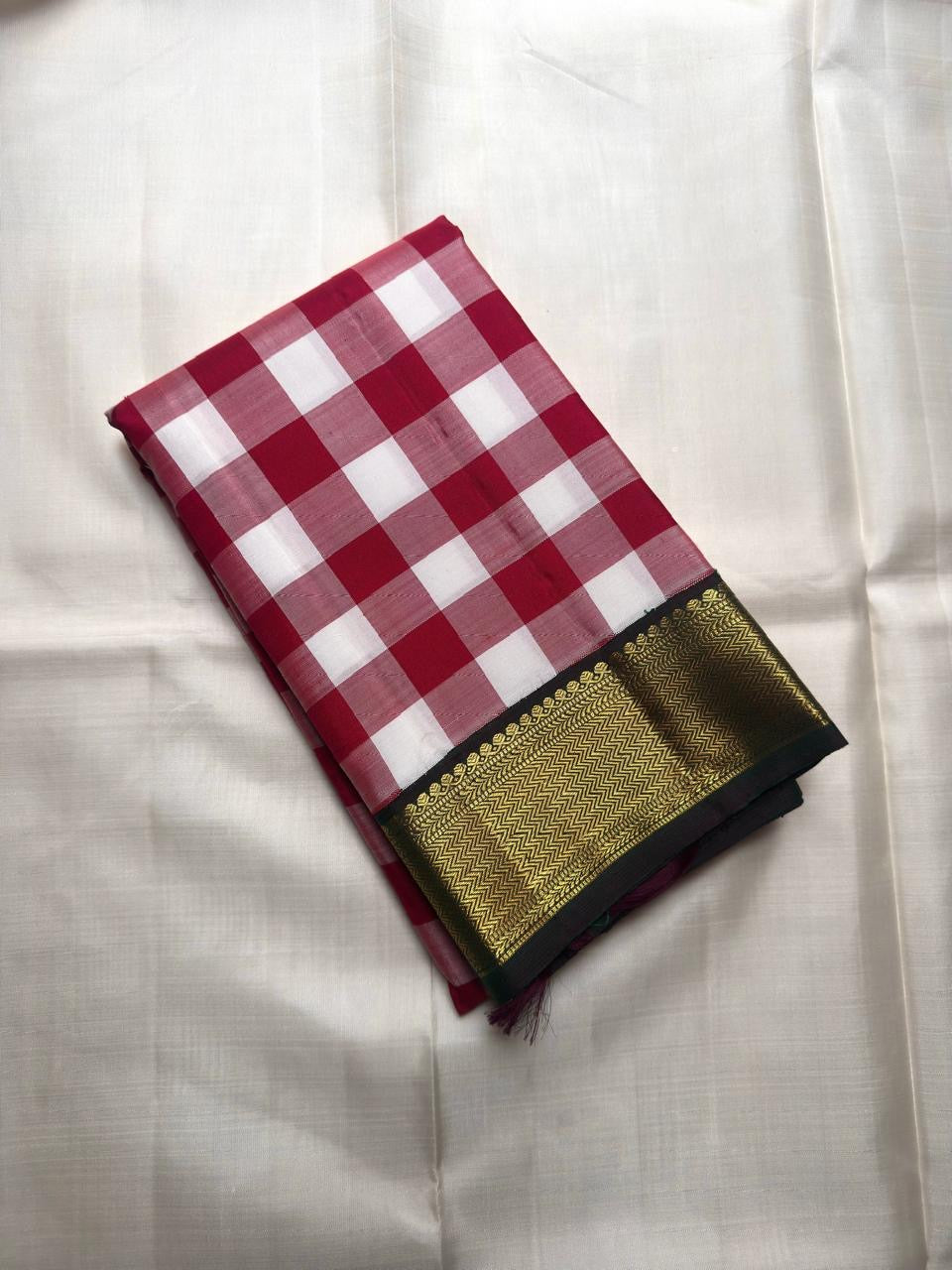 Handwoven pure silk Kanchipuram Paalum Pazhamum saree in bottle green with a rose pink and white checked blouse piece and broad gold zari border.