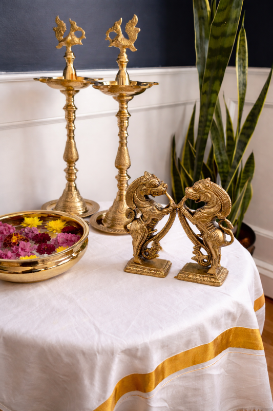 Handcrafted brass Yazhi statue pair facing each other with lotus flower and peacock feather traditional decor styling