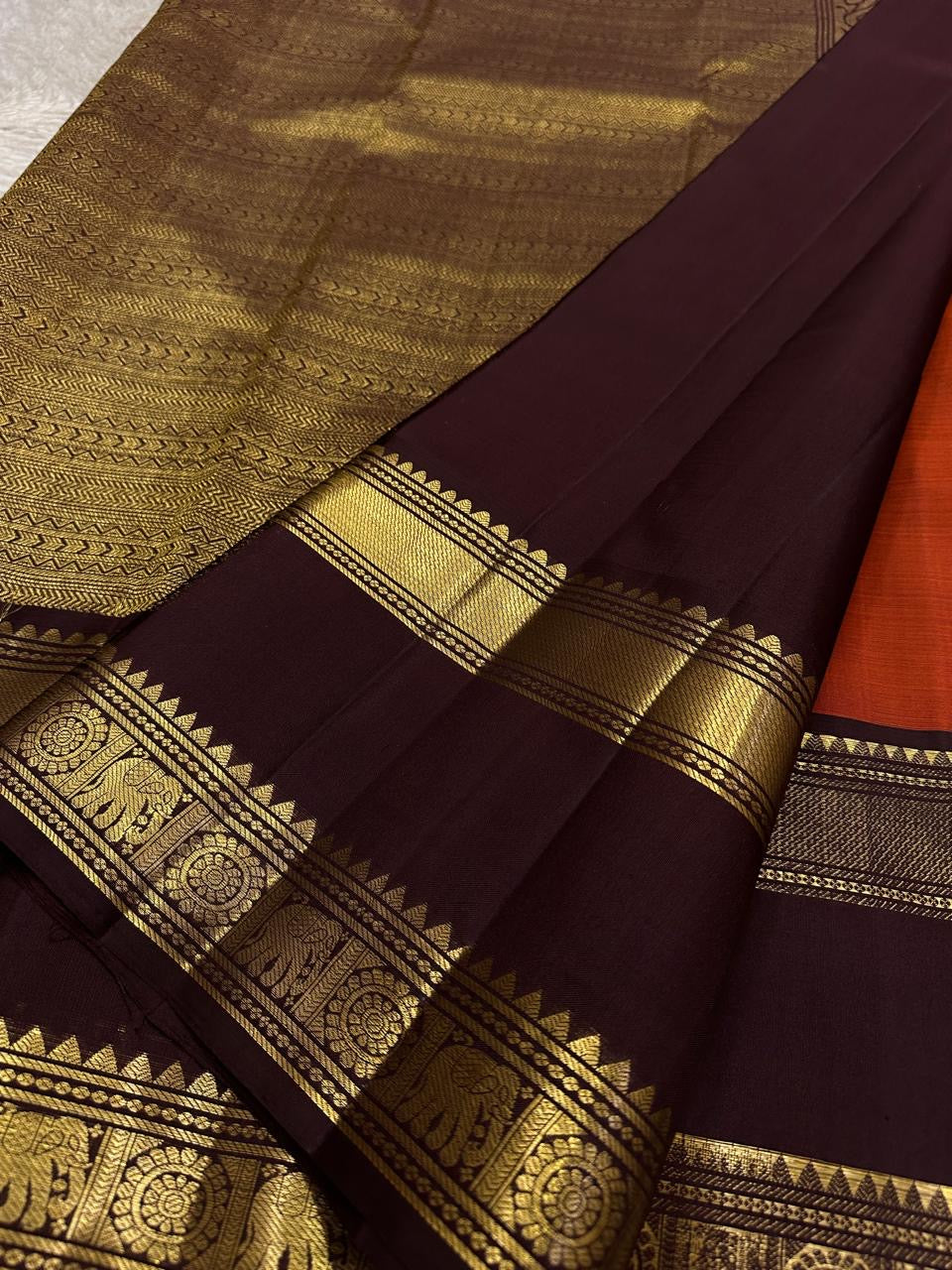Deep maroon temple-motif border on brick red Kanjeevaram silk saree