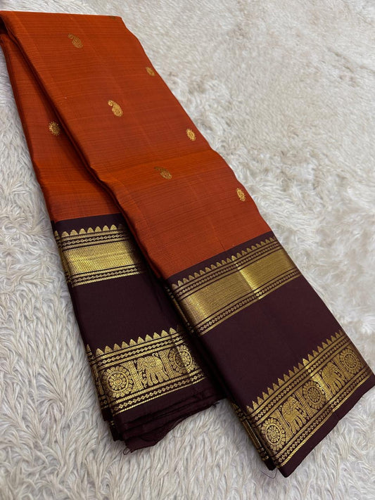 Brick red Rettapet Kanchipuram silk saree body close-up with gold zari buttas