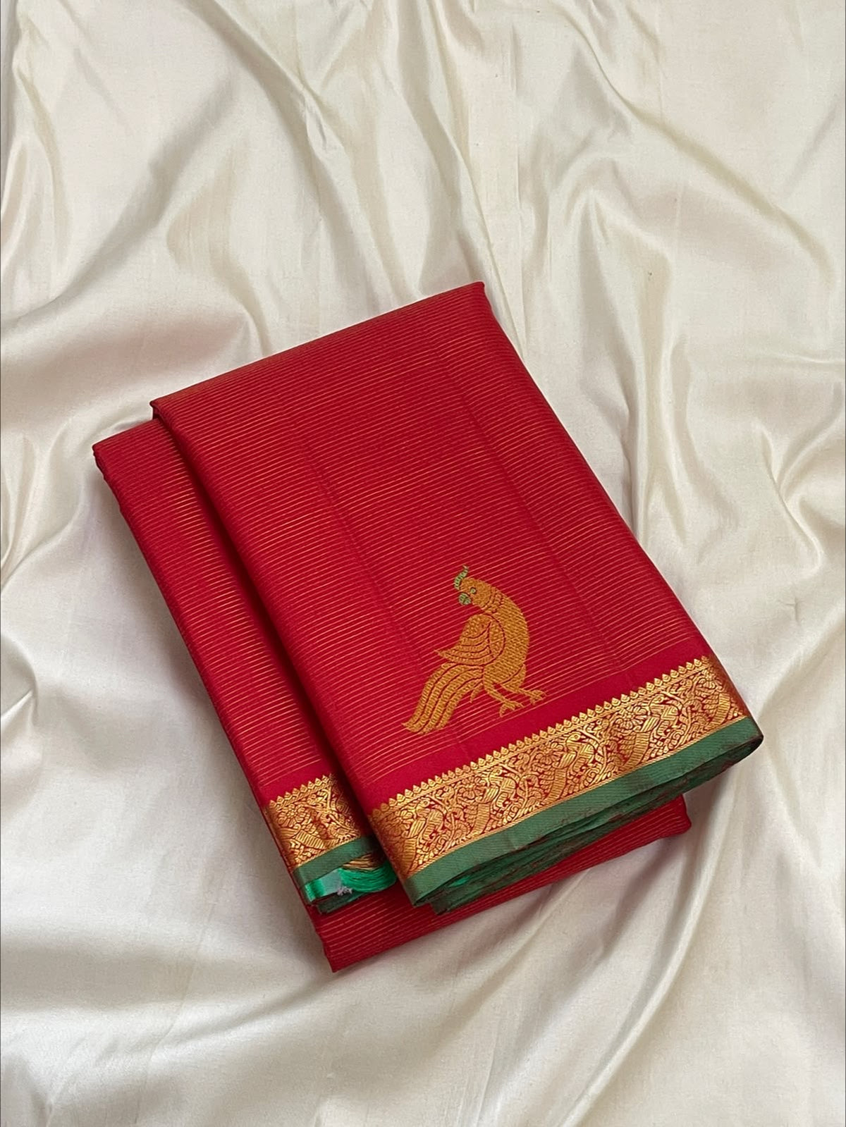 Vermilion red Vairaoosi Kancheepuram silk saree with deep emerald green edging, folded view — Idam Living