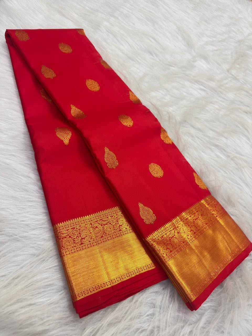 Mayil and floral zari buttas spaced across bright red Kanchipuram silk