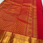 Gold zari peacock and floral detail along the border of bright red Kanchipuram silk