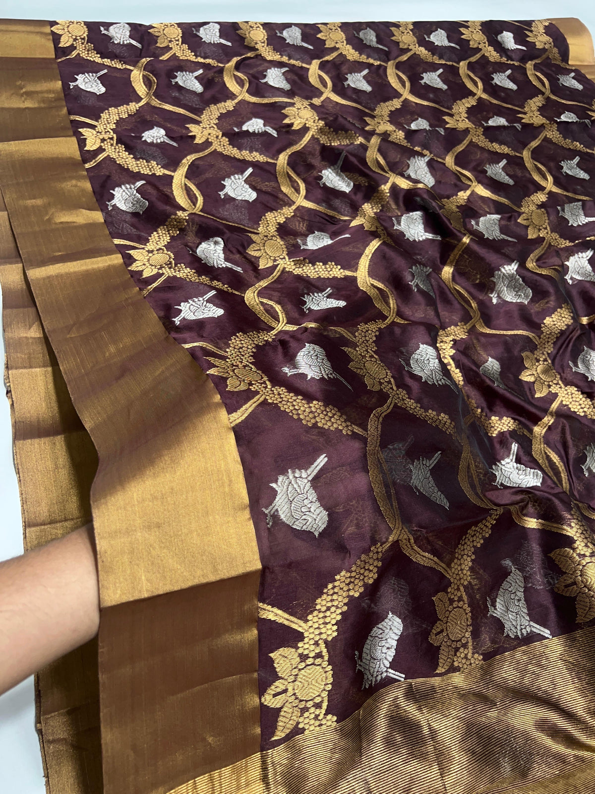 Close-up of gold floral-vine lattice and silver-tone bird motifs on the Deep Cocoa Brown Pattu Silk Chanderi saree.