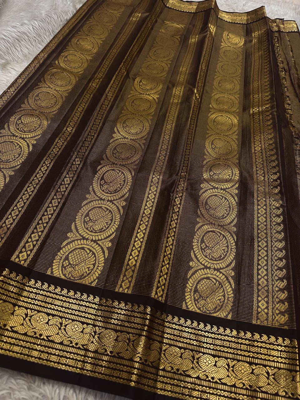 Close view of stylized bird motifs woven into Kanchipuram gold zari border