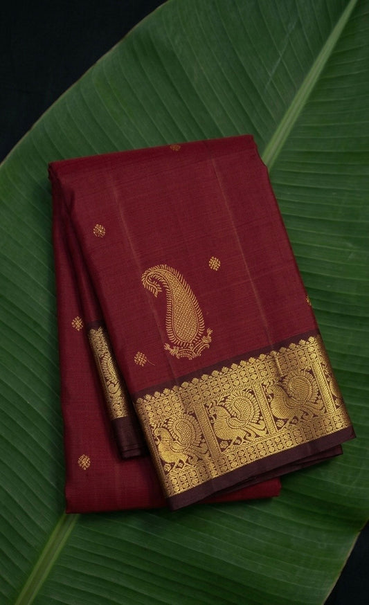 Kanchipuram silk saree in burgundy red with deep coffee brown border Maanga Butta weave folded view