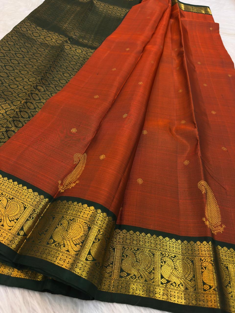 Close view of warm-gold Mayil motifs and ornamental zari registers on deep green border