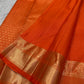 Close view of antique-gold zari butta motifs on Burnt Orange Kanjivaram silk.