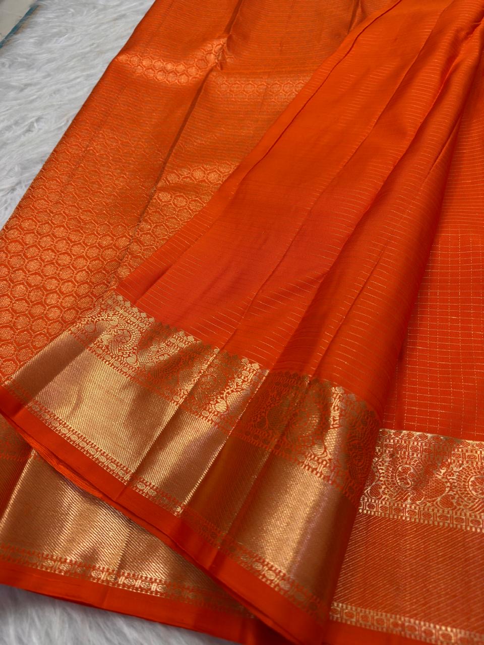 Close view of antique-gold zari butta motifs on Burnt Orange Kanjivaram silk.