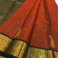 Close view of handwoven zari paisley buttas across luminous rust orange pure silk body
