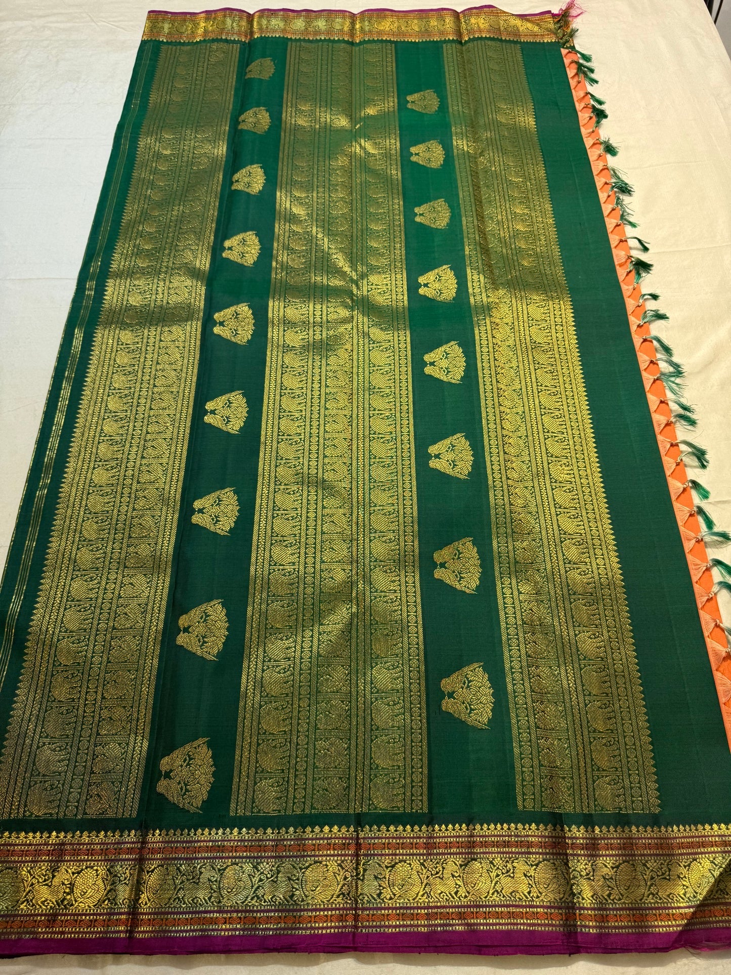 Close view of antique gold Gandaberunda motif on Burnt Orange Kanjivaram silk