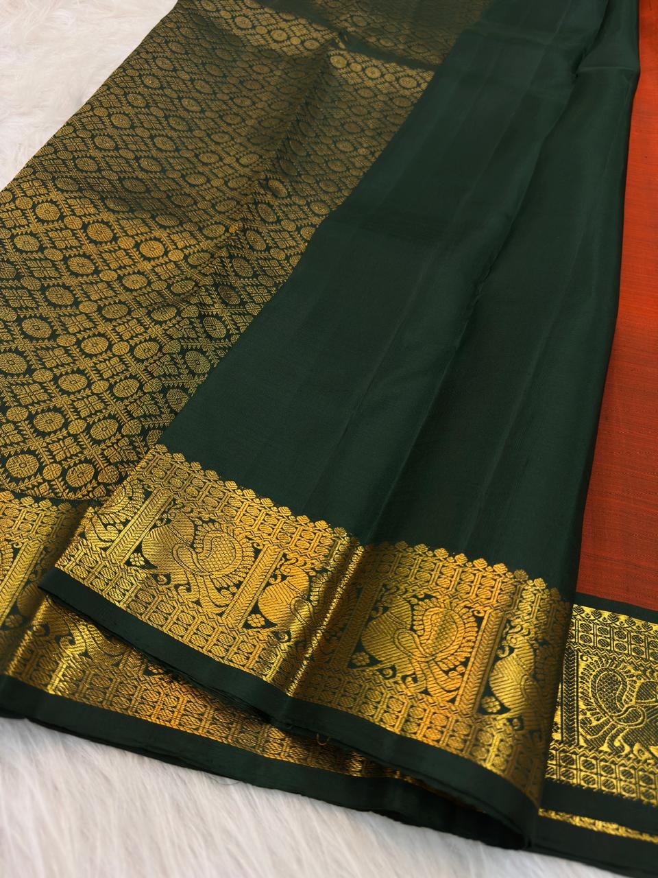 Burnt Orange Kanchipuram silk saree with handwoven gold zari paisley buttas and green border