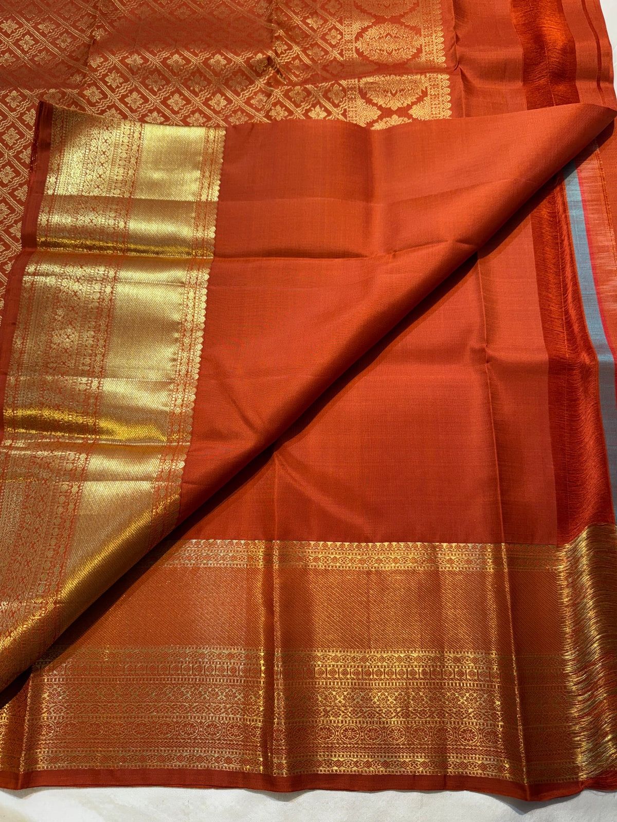 Burnt-orange Pure Silk Kanchipuram saree draped, showing the warm brown undertone