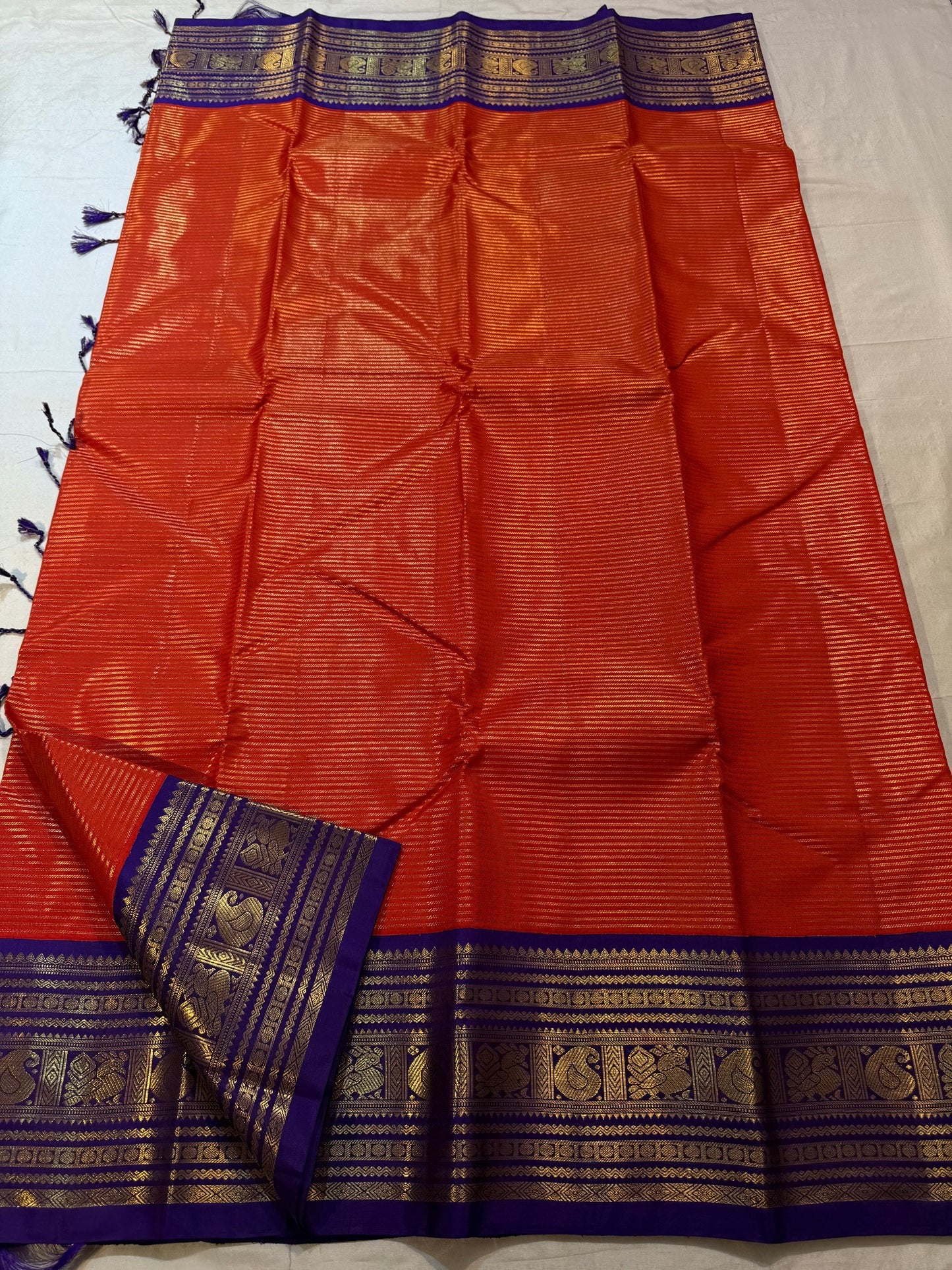 Burnt Orange Kanchipuram silk saree with fine antique-gold zari lines.