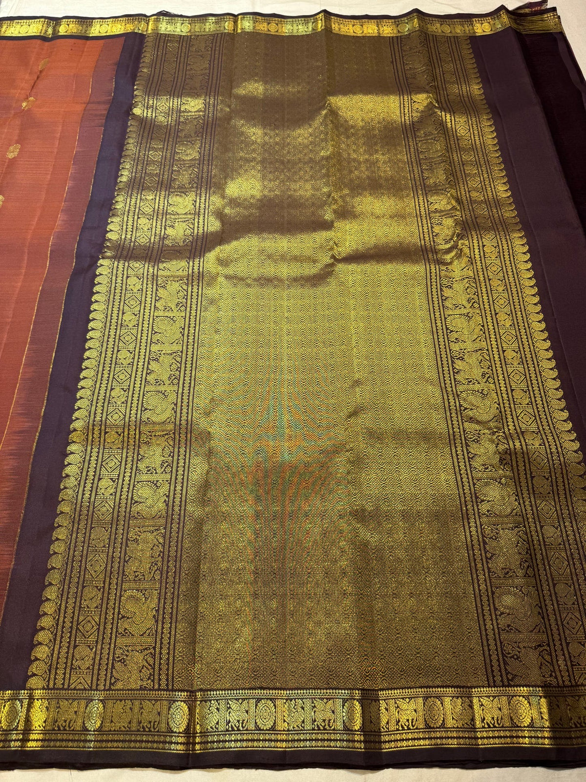 Burnt Rust Kanchipuram silk saree with individually spaced antique-gold zari buttas.