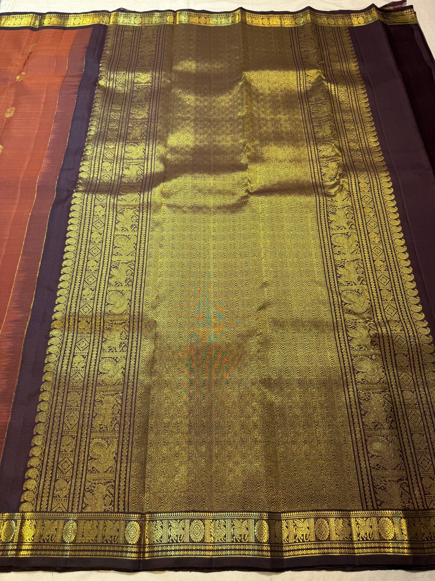 Burnt Rust Kanchipuram silk saree with individually spaced antique-gold zari buttas.