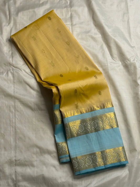 Long-folded butter yellow Pure Kanchipuram silk saree with small buttas and sky blue zari woven border detail
