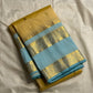 Folded butter yellow Pure Kanchipuram silk saree with sky blue border and zari woven floral band on white backdrop